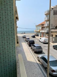 a row of cars parked on a street next to the beach at T4 Furadouro with sea view in Furadouro
