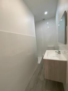 a white bathroom with a sink and a mirror at T4 Furadouro with sea view in Furadouro