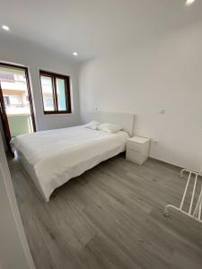 a white bedroom with a large bed and a window at T4 Furadouro with sea view in Furadouro +4 photos