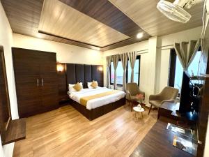 Un dormitorio con una cama y un televisor en una habitación. en Hotel Jannat, en Dalhousie