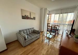 een woonkamer met een bank en een tafel bij Happy holidays Madrid in Madrid