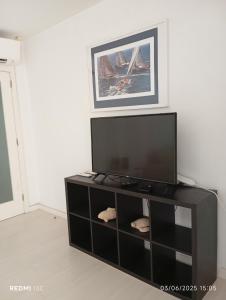 Un centro de entretenimiento negro con un televisor de pantalla plana. en T2 Furadouro 30m from the beach, en Furadouro