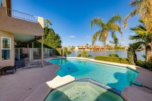 una piscina frente a una casa con un cuerpo de agua en Lakefront Living! Huge Phoenix Home with Dock, Pool, en Phoenix