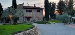 a stone house with a stone wall next to a yard at Agriturismo Amici Miei in Lastra a Signa