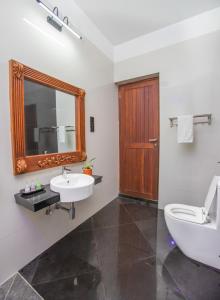 a bathroom with a sink and a toilet and a mirror at Clara Villas Amithirigala in Avissawella