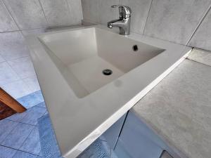 a white sink with a faucet in a bathroom at Appartamento Town Center in Predazzo +23 photos
