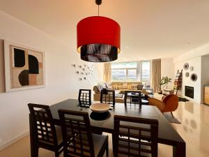a dining room and living room with a red chandelier at Casa Andorinha With Private Pool & Coastal Views in Foz do Arelho
