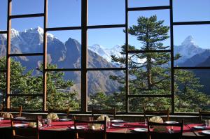a dining room with a view of mountains through a window at Hotel Everest View in Khumjung