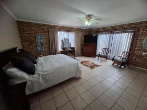 a bedroom with a bed and a tv in it at Addo River Den 4 in Gqeberha