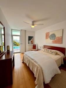 a bedroom with a large bed with a ceiling fan at Casa Andorinha With Private Pool & Coastal Views in Foz do Arelho +51 photos