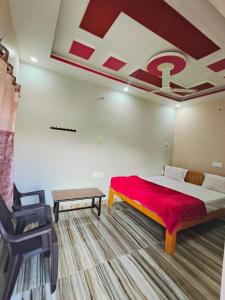 a bedroom with a large bed with a red blanket at Sumathi homestay in Hospet