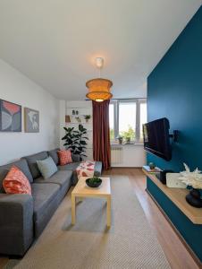 ein Wohnzimmer mit Sofa und Fernseher in der Unterkunft Bella Luna Luxury Suites - Warm & Modern Apt Near Old Town & Museums in Warschau