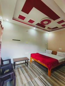 Un dormitorio con una cama grande con una manta roja. en Sumathi homestay, en Hospet