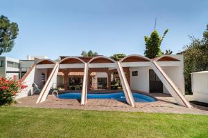 a swimming pool in a backyard with an archway at Casa Mexicana con Alberca Techada y Jardín in Tequisquiapan