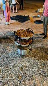 a group of food in pans on a beach at Sama Wadi Rum Luxury Camp in Wadi Rum