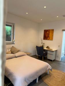 a bedroom with a bed and a desk with a chair at Modernes Apartment - Kirchfeld in Karlsruhe