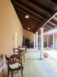 una habitación con techos de madera, sillas y mesas en CalmDown, en Ahangama