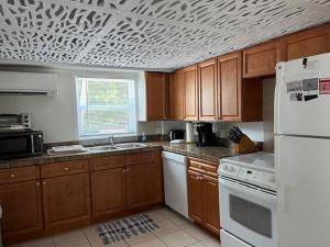 a kitchen with a white refrigerator and wooden cabinets at Gulf Front Cottages in Englewood