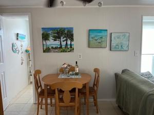 a dining room with a table and chairs and a bed at Gulf Front Cottages in Englewood