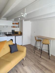 a living room with a couch and a table at Chez madame Hulotte in Saint-Nazaire