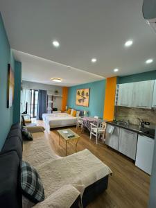 ein Wohnzimmer mit Couch und Küche in der Unterkunft Your Cozy Stay - Tirana in Tirana