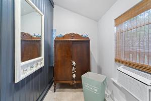 a bathroom with a wooden cabinet and a window at Margate Home w/ Large Outdoor Kitchen in Margate City +16 photos