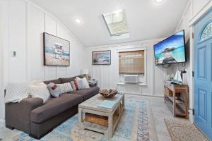 a living room with a couch and a tv at Margate Home w/ Large Outdoor Kitchen in Margate City