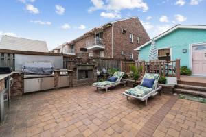 a patio with two chairs and a grill and a house at Margate Home w/ Large Outdoor Kitchen in Margate City