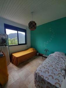 Un dormitorio con una cama y una ventana grande. en Maison atypique avec vue unique, en Le Carbet