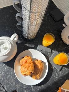 a plate of food on a table with orange juice at Cosy stylish house West Hull in Hull