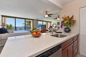 a kitchen with a counter top with a bowl of fruit on it at Mahana 602 · MA 602 Kaanapali OceanFront Studio Ocean View Pool in Kahana