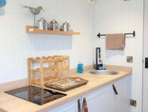 a kitchen with a sink and a counter top at The Shepherd's Hut on the Beach - Pagham - Sea Front in Pagham +16 photos