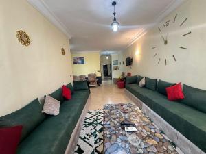 a living room with a couch and a clock on the wall at Location Appartement tangier malabata in Tangier
