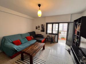 a living room with a green couch and a table at La Casa del Musico 1 in Almería