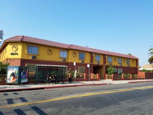 un bâtiment jaune et rouge au coin d'une rue dans l'établissement Central Inn Motel, à Los Angeles