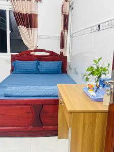 Ấp Bình HưngにあるSEA HOME HOMESTAYのベッドと机とテーブルのある寝室
