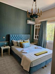 a bedroom with a blue bed and a chandelier at Allegoria House in Nafplio