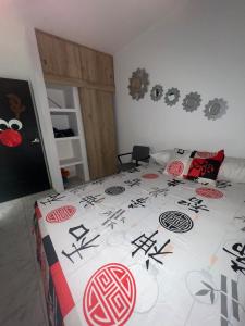 a bedroom with a bed with a comforter with asian writing at Alojamiento completo - Casa en Conjunto con 2 habitaciones in Florencia