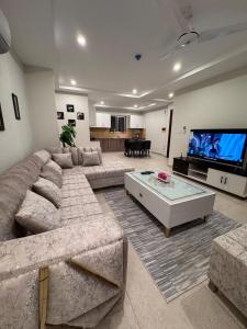 a large living room with a large couch and a tv at JW Apartments in Dargai