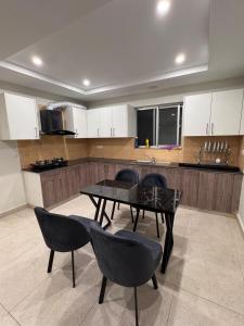 a kitchen with a table and chairs and a counter at JW Apartments in Dargai