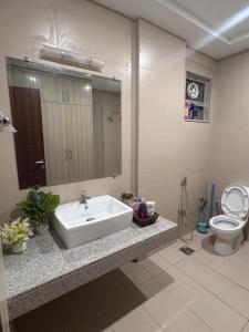 a bathroom with a sink and a toilet at JW Apartments in Dargai