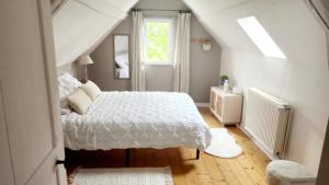 a bedroom with a white bed and a window at Gîte le clos Normand in Saint-Jouin-Bruneval