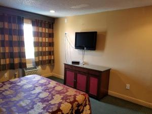 a bedroom with a bed and a flat screen tv at Central Inn Motel in Los Angeles