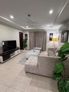 a living room with a couch and a tv at JW Apartments in Dargai