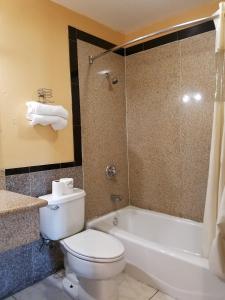 La salle de bains est pourvue de toilettes, d'une baignoire et d'un lavabo. dans l'établissement Central Inn Motel, à Los Angeles