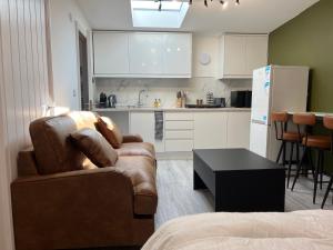 a living room with two chairs and a kitchen at Little studio flat in Southgate
