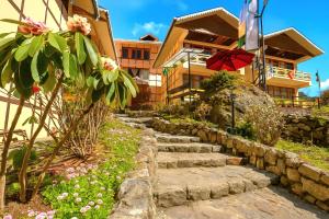 a stone path in front of a building with a red umbrella at The Country House by Trekocity in Lachung