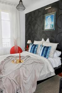 a bedroom with a large bed with a candle on a tray at Urban Lux Colombes in Colombes
