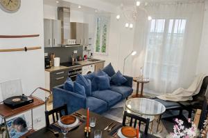 a living room with a blue couch and a kitchen at Urban Lux Colombes in Colombes