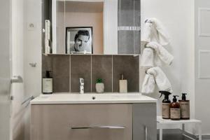 a bathroom with a white sink and a mirror at Urban Lux Colombes in Colombes +29 photos